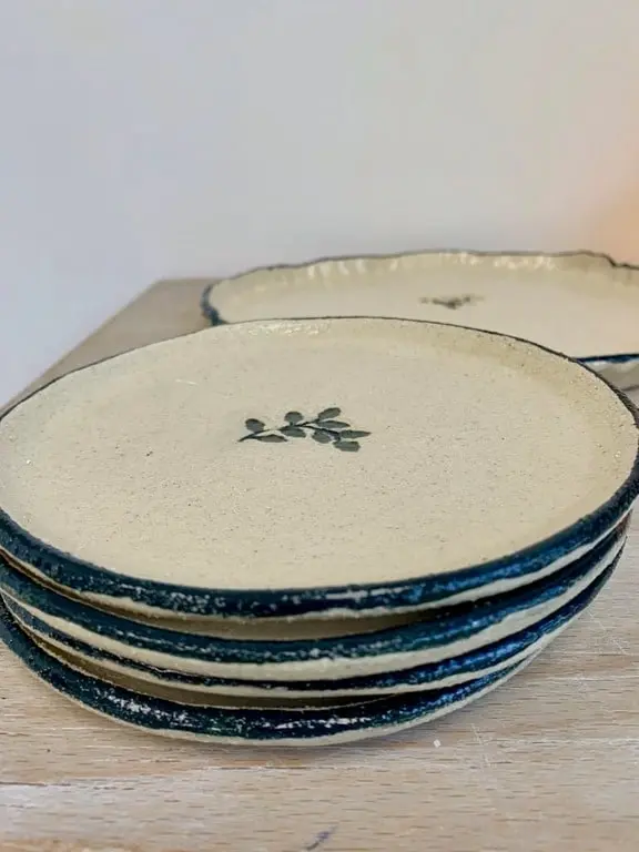 Pile d'assiettes en grès à liseré bleu et motif de feuille