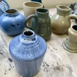 Pots, vases et pichets émaillés bleu et gris dans l'atelier