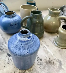 Pots, vases et pichets émaillés bleu et gris dans l'atelier