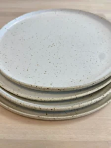 Pile d'assiettes en grès moucheté blanc crème