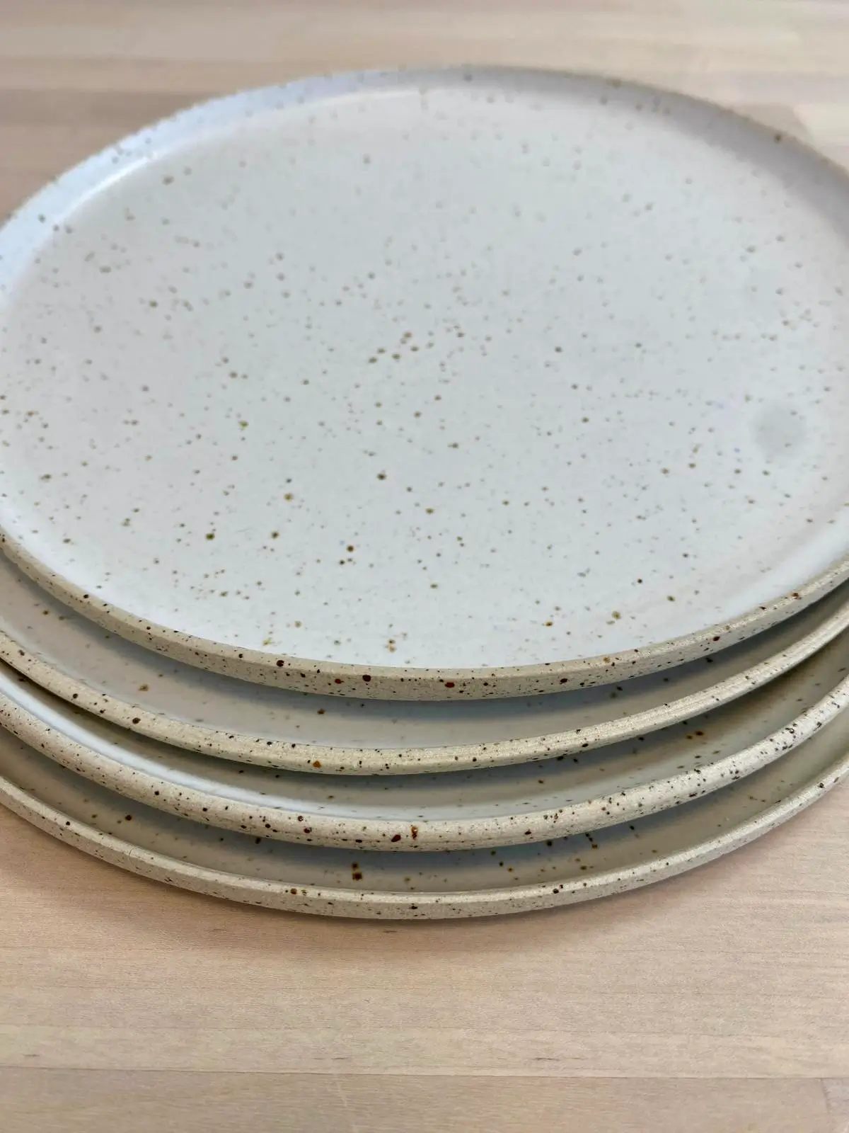 Pile d'assiettes en grès moucheté blanc crème