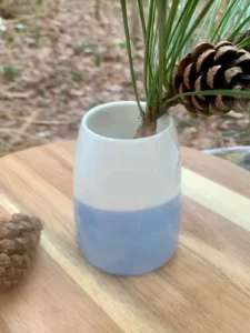 Vase en porcelaine bicolore blanc et bleu clair avec branche de pin