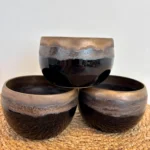 Trois bols en céramique émaillée noir obsidienne à reflets dorés