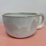 Tasse en céramique émaillée blanc et gris, faite main, sur fond rose