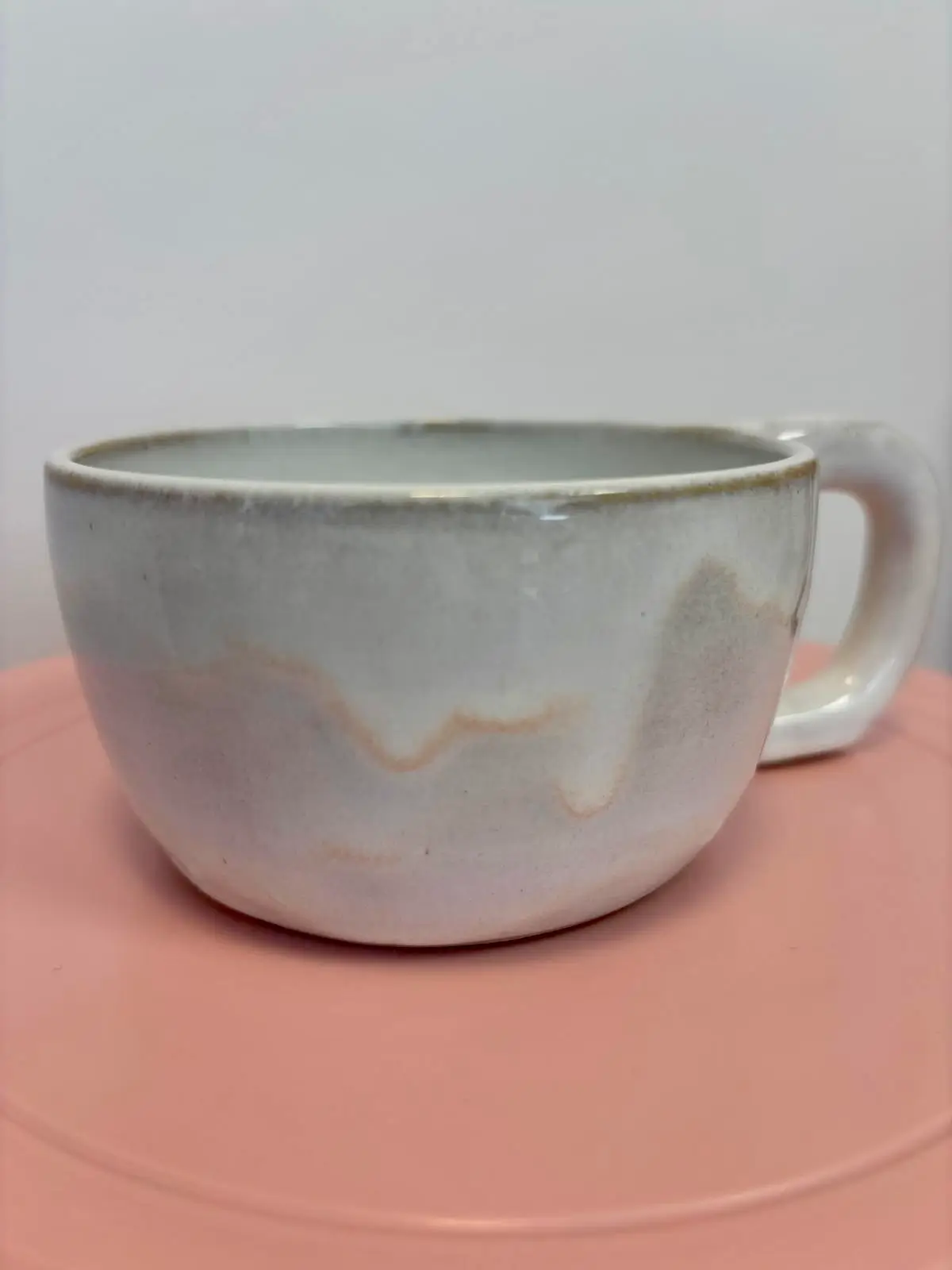 Tasse en céramique émaillée blanc et gris, faite main, sur fond rose